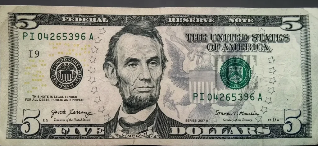 Close-up of a 5 dollar bill slightly curved